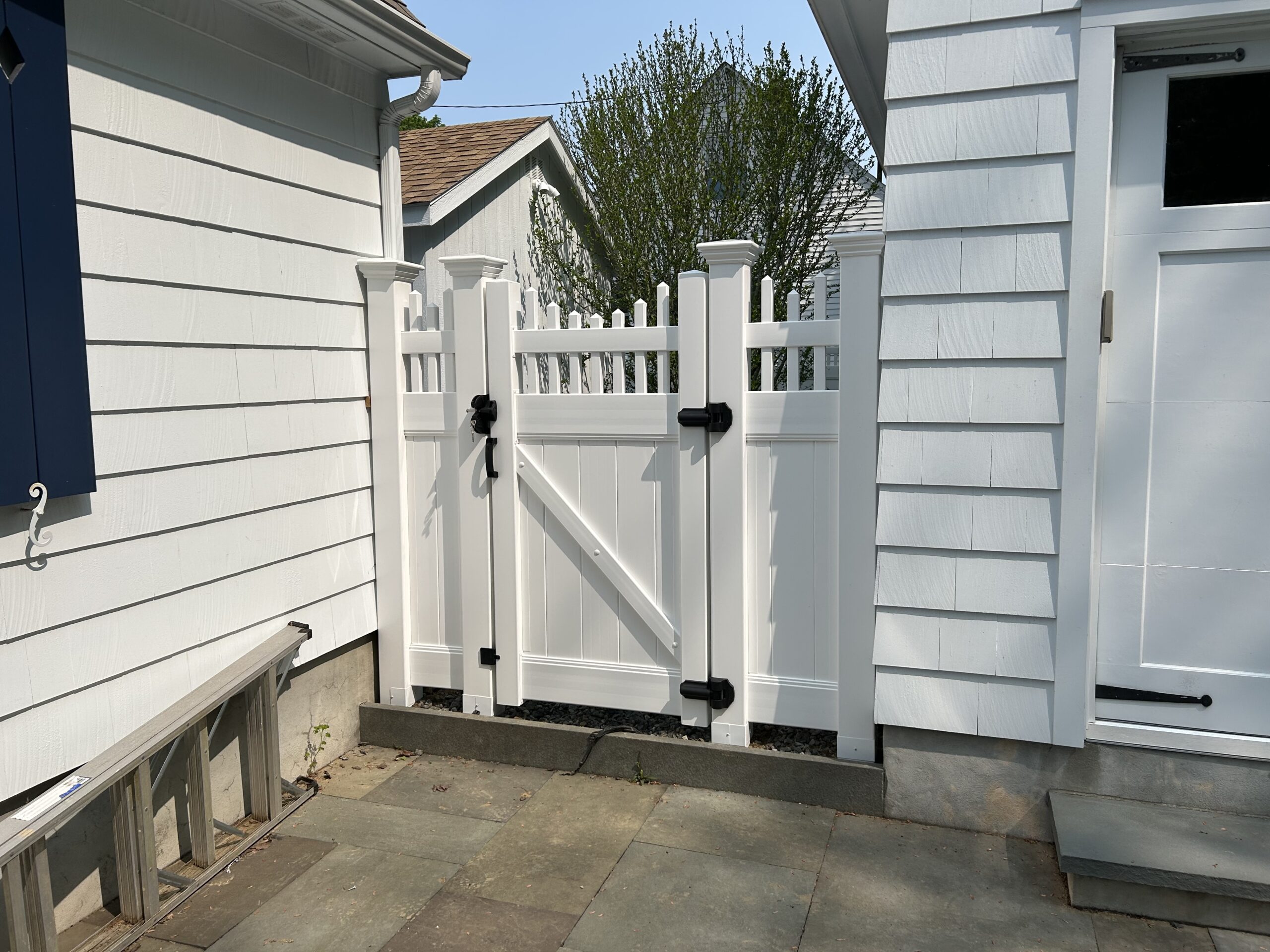 White vinyl picket gate with black hardware installed by Arrow Fence