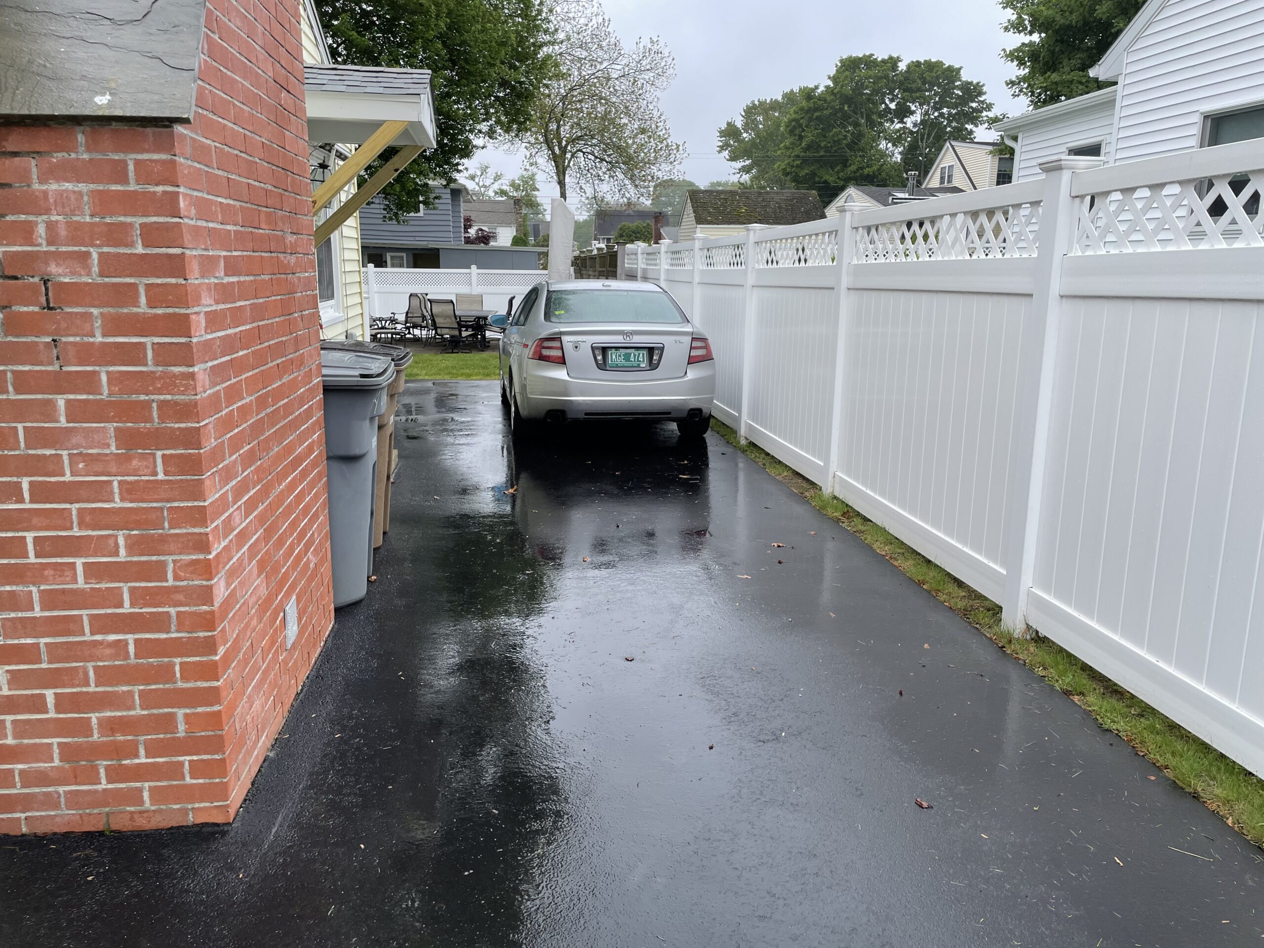 White vinyl privacy fence separating driveways between Connecticut homes