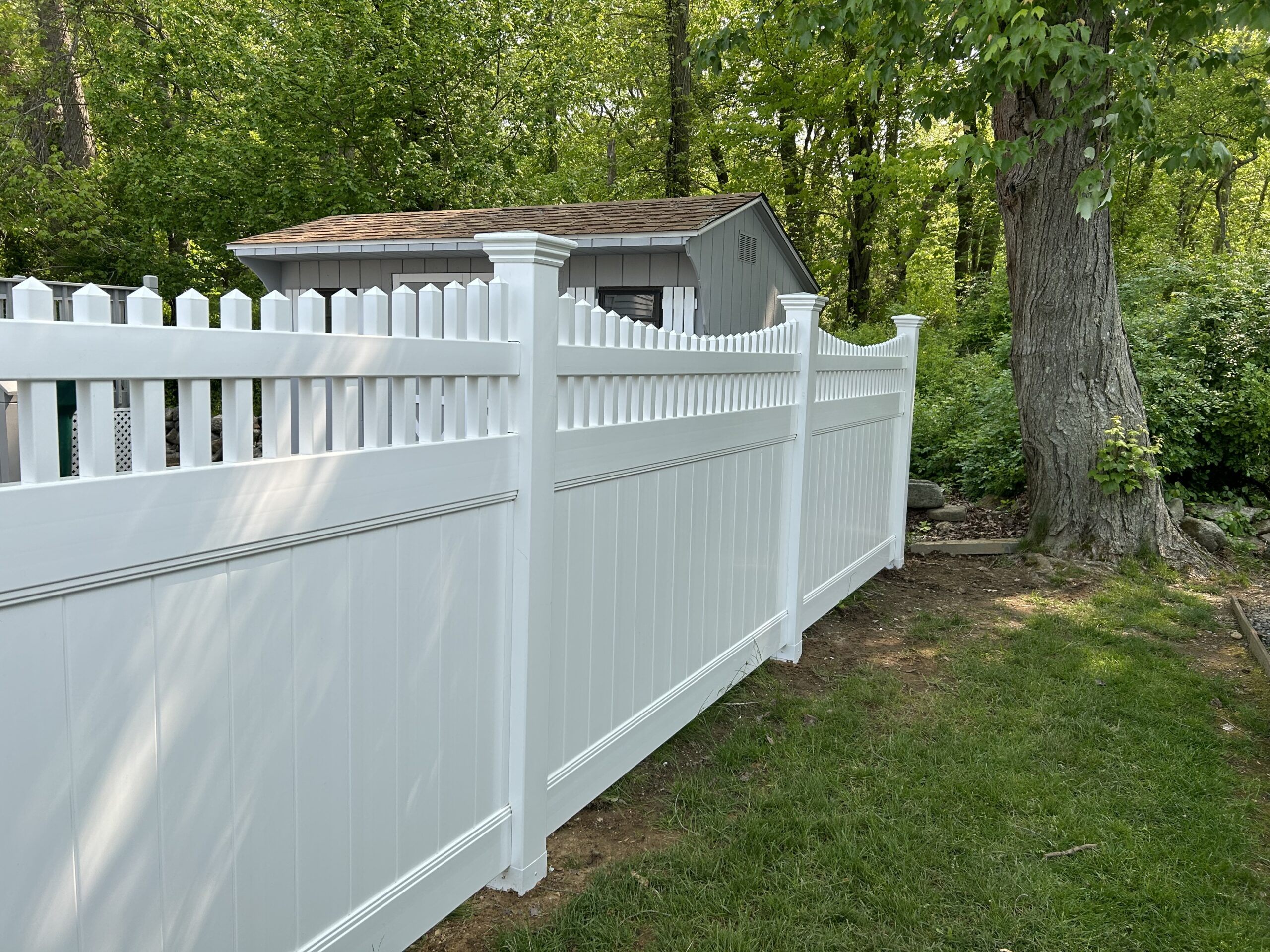 White vinyl privacy fence installed by Arrow Fence near a garage in Connecticut