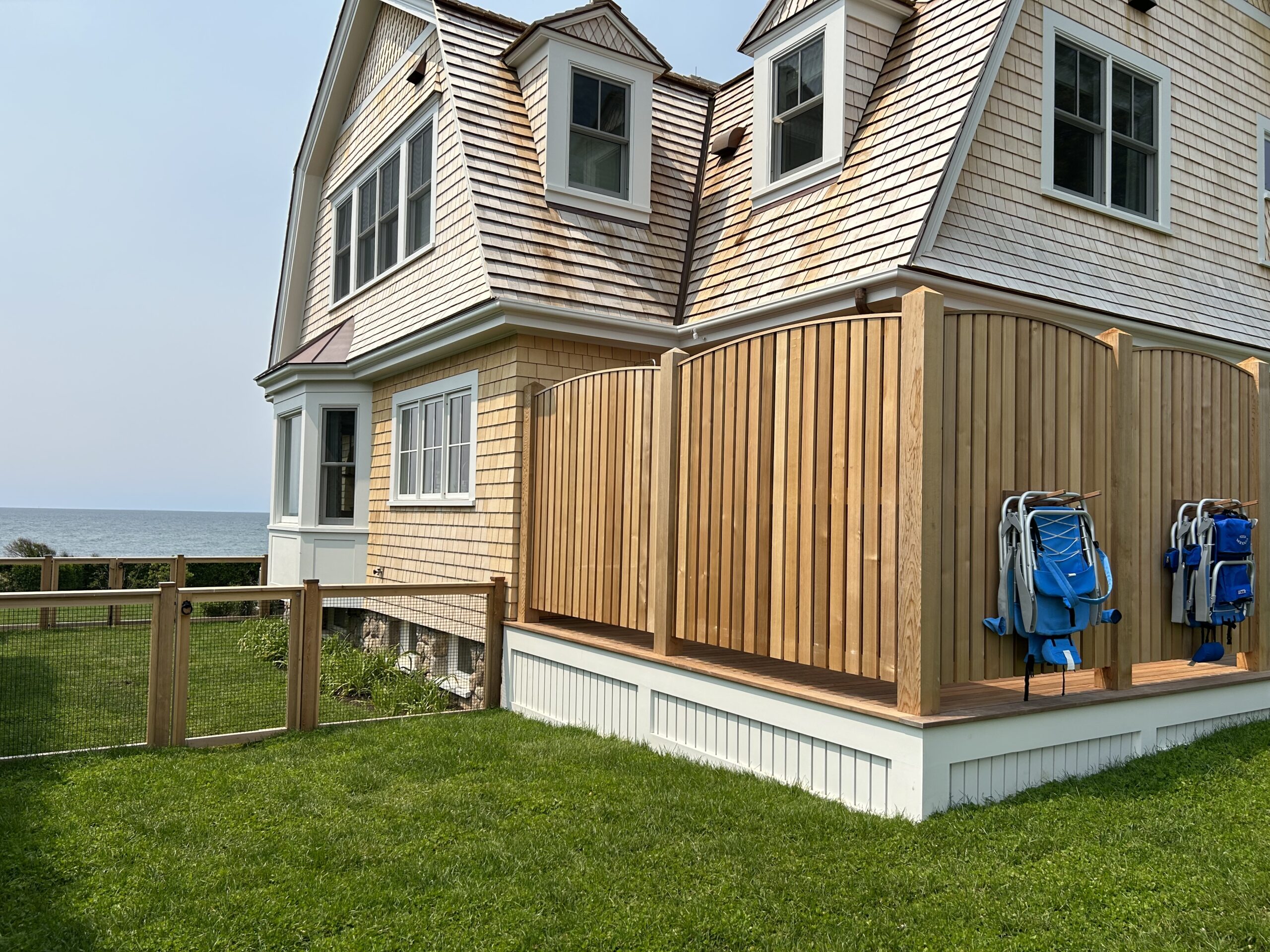 Arched cedar privacy fence enclosing a beachside deck in Connecticut