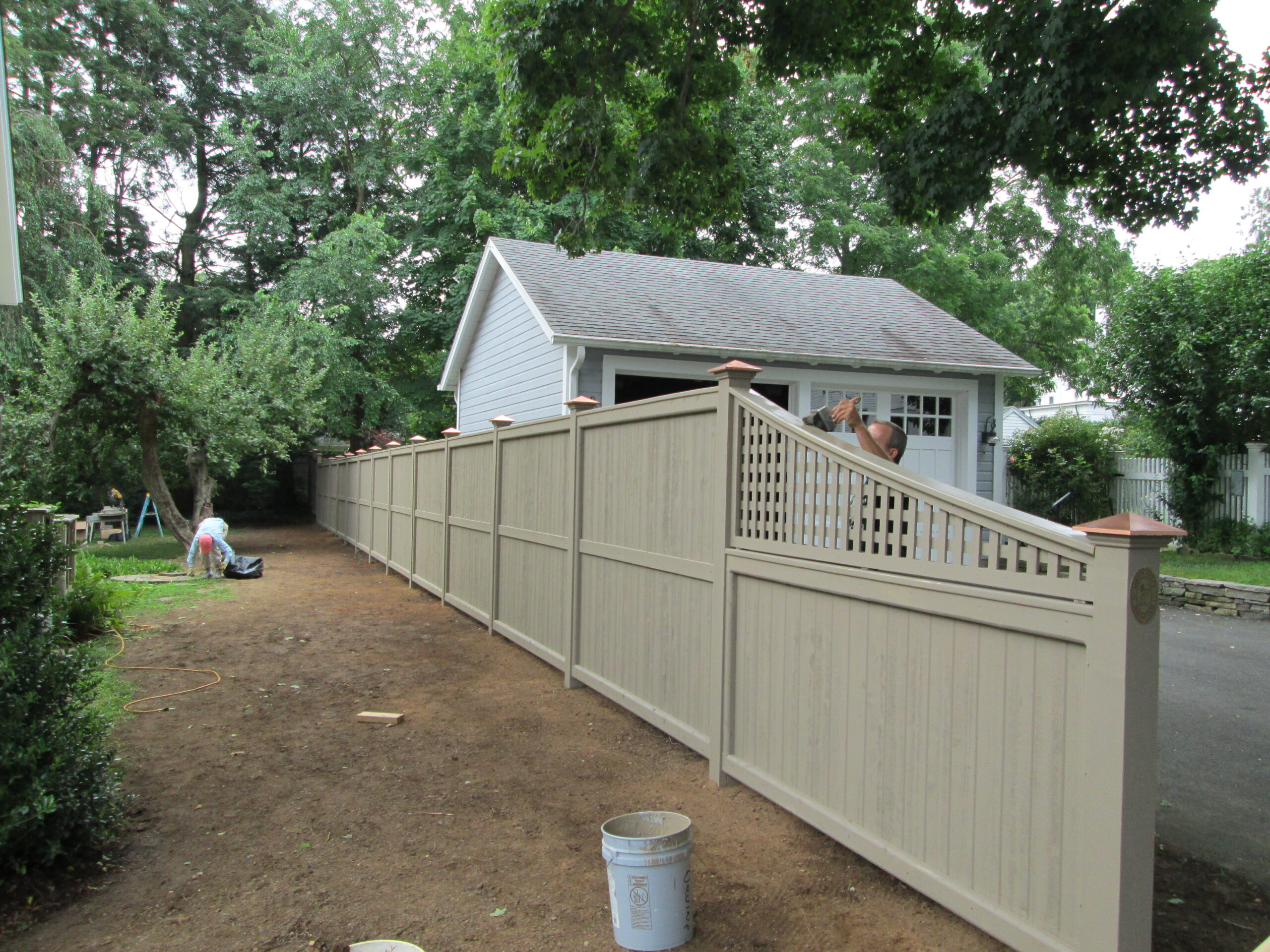 Stained cedar privacy fence with copper post caps installed by Arrow Fence in Connecticut