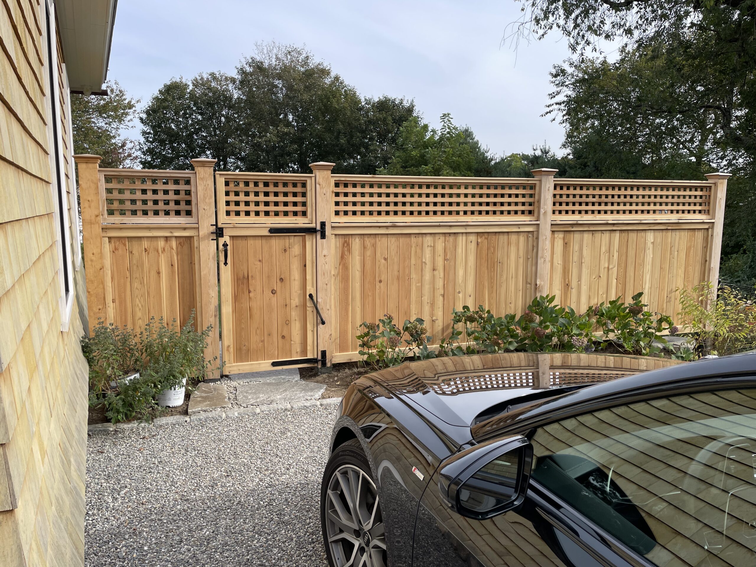 Cedar privacy fence and gate with square lattice topper by Arrow Fence