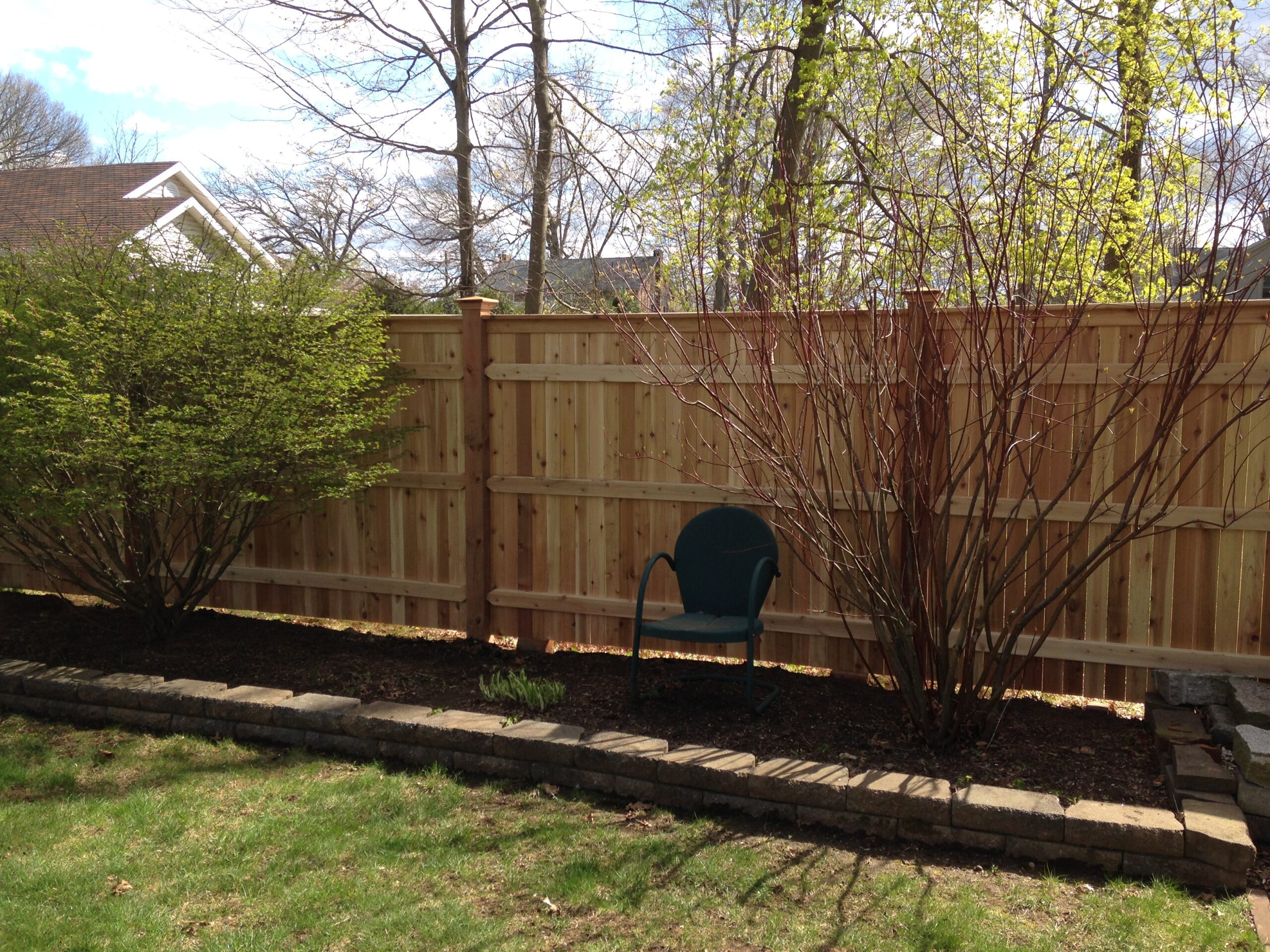 Six-foot cedar board privacy fence with garden bed along a Connecticut property line